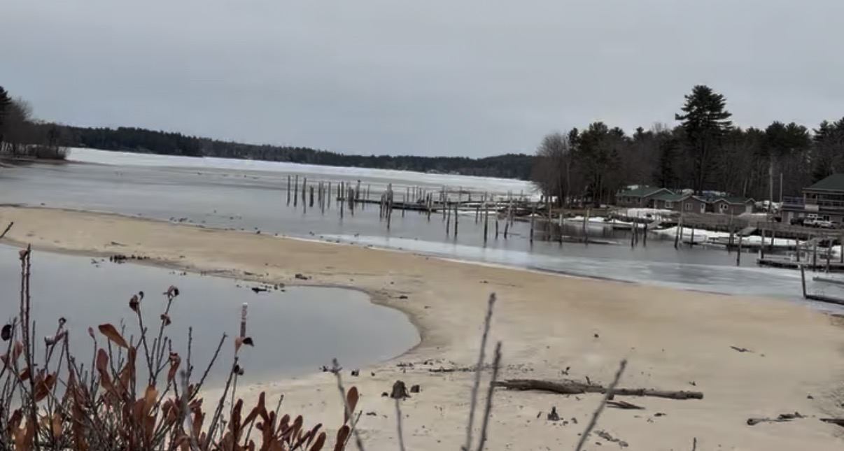 Brandy Pond on March 13, 2026 — ice melted near the marina but still covering the main body of the pond