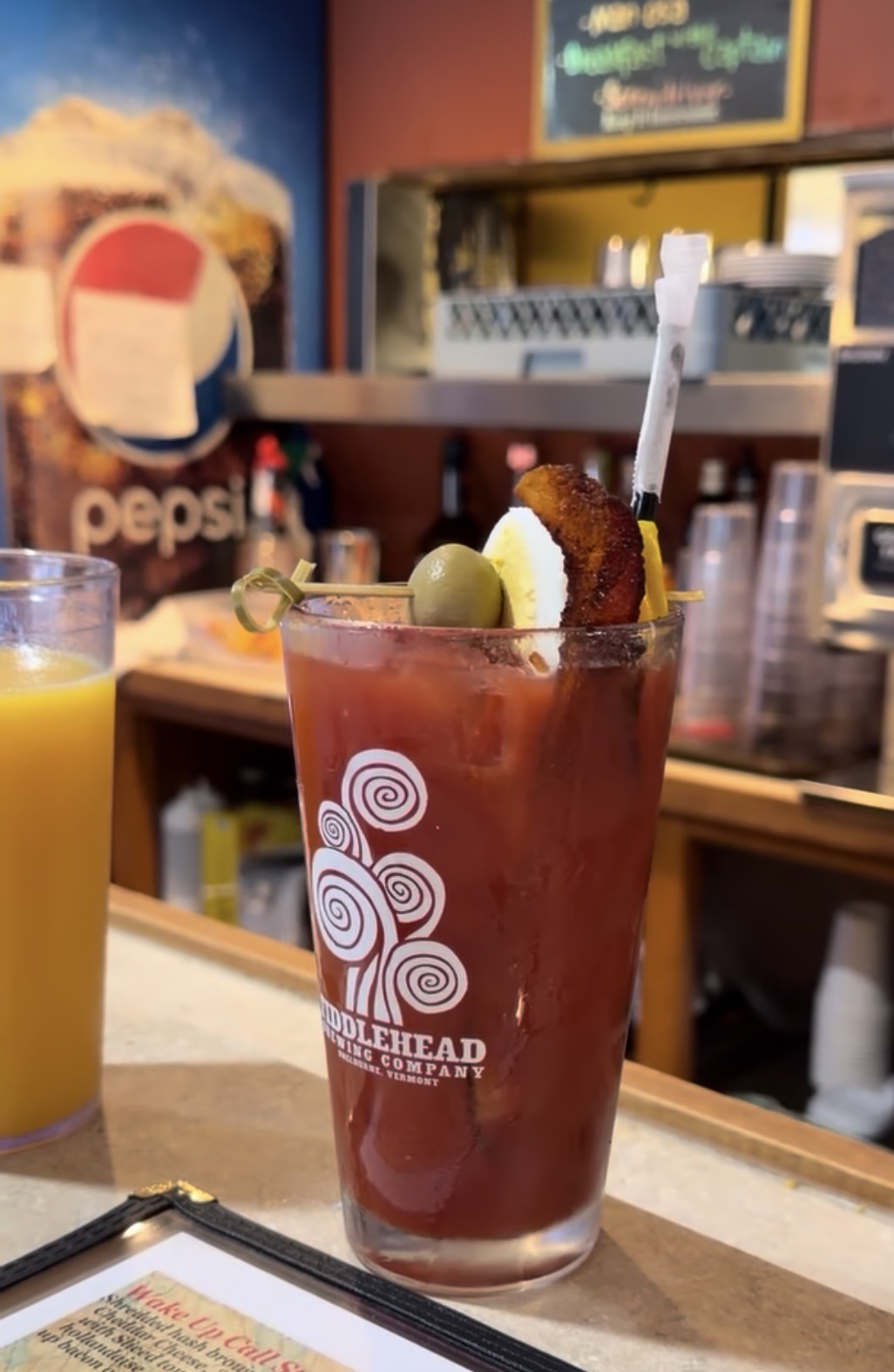 Bloody Mary garnished with bacon, olive, egg, and pickle at Kelley's Sebago Diner