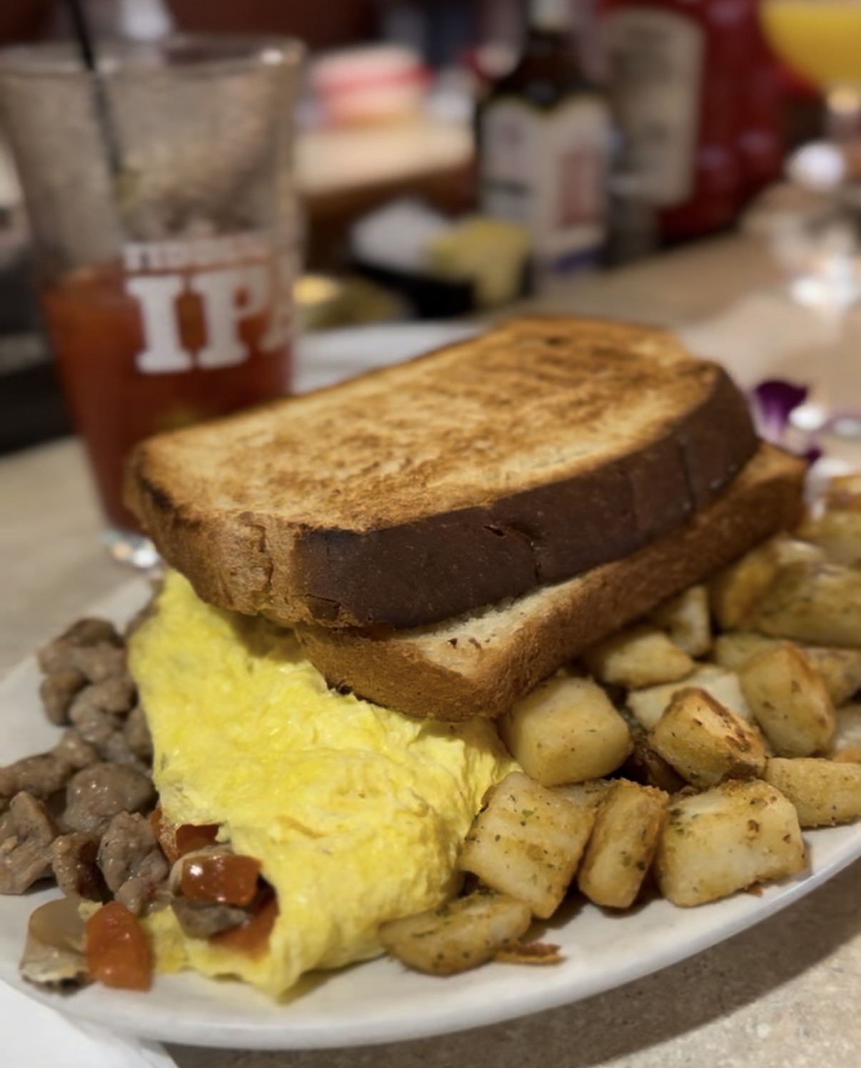 Sausage and pepper omelet with toast, home fries, and a side of sausage