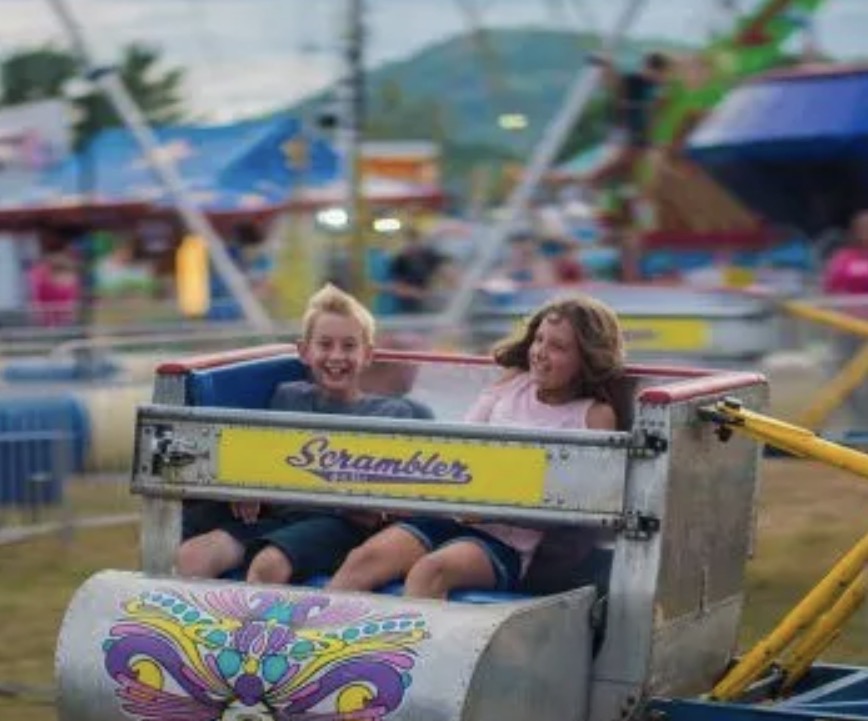 Two kids laughing on the Scrambler ride at the Oxford County Fair